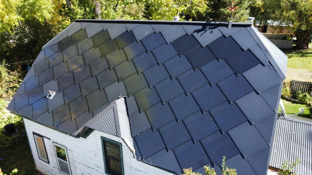 Installation process of an interlocking dark blue SunStyle solar shingle.