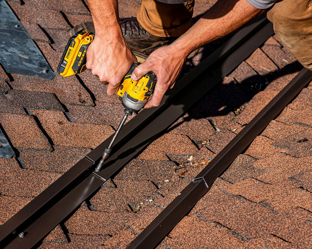 Roofing worker securing metal edging with a power tool.