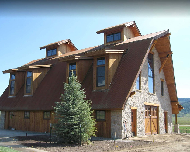 Exterior of a modern mountain home with new roofing and stone siding.